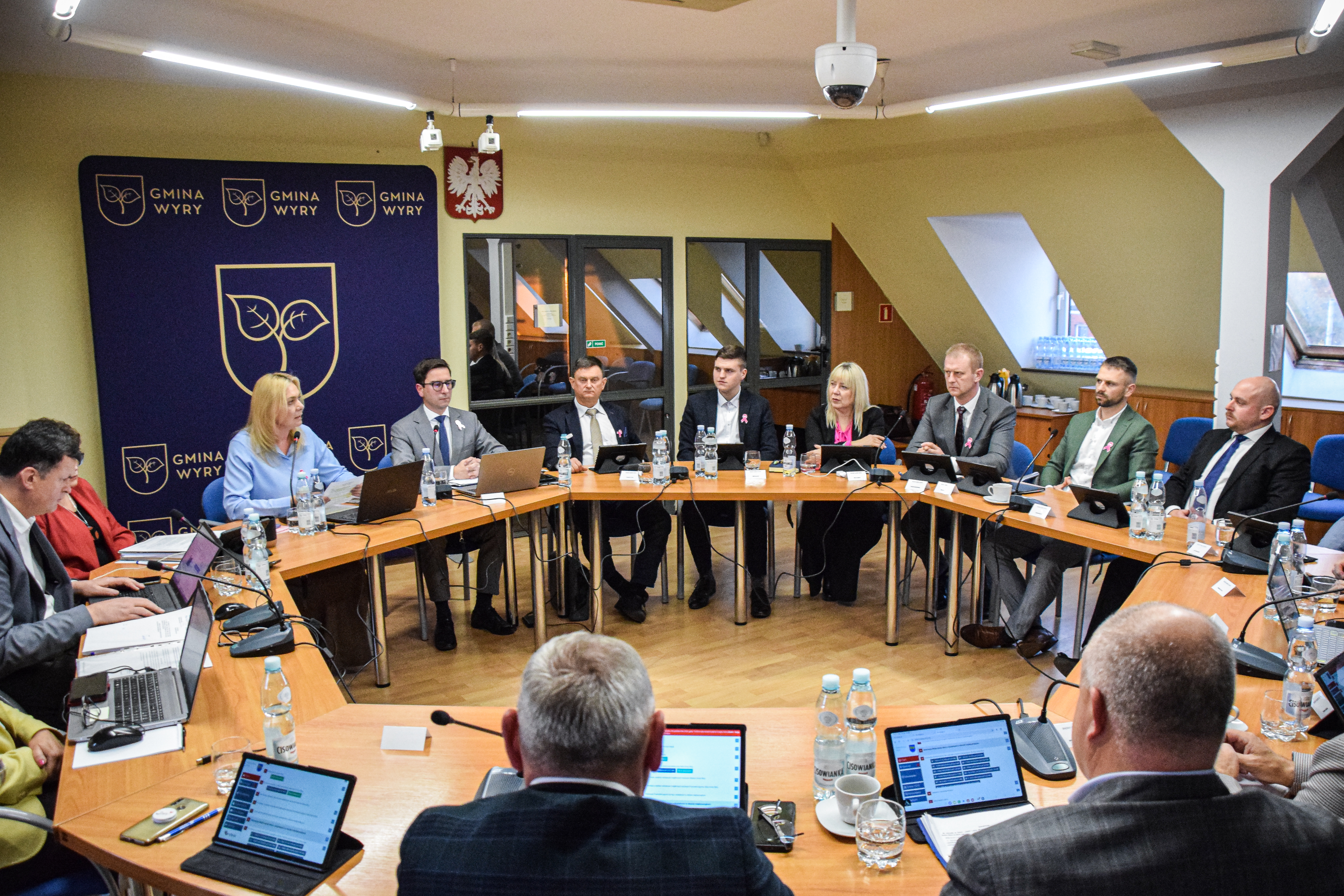 Radni Gminy Wyry podczas obrad siedzą przy okrągłym stole.jpg